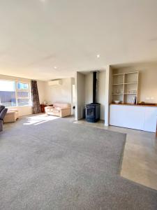a living room with a fireplace and a couch at West Meadows Escape, Lake & Slopes Minutes Away in Wanaka
