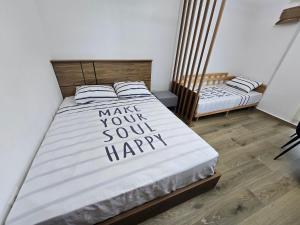 a bedroom with a bed with the words make your soul happy at Olive Breeze Drymades in Dhërmi