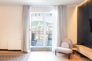 a living room with a chair and a sliding glass door at Bukville Hotel & SPA in Bukovel