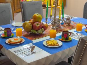 a table with a breakfast of eggs and fruit at Hotel Boutique Casa Lili in Tunja