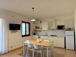 a kitchen with a wooden table and white appliances at CasaMirea in Lipari