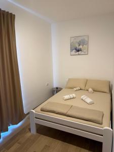 a bedroom with a bed with two pillows on it at Apartmani Stefanos - Jaz in Budva