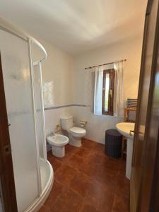a bathroom with two toilets and a shower and a sink at La Casina Del Mercao in Aldeanueva del Camino