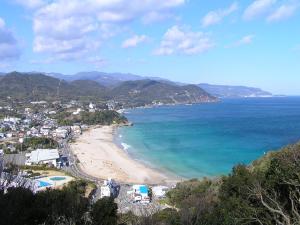 a view of a beach with a town and the ocean at Guest House SUN Izu Shirahama in Shimoda