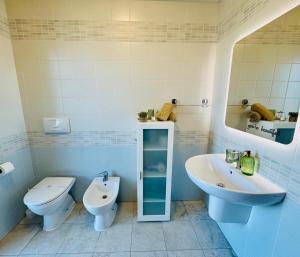 a bathroom with a toilet and a sink at Cagliari AirPort Apartment in Elmas