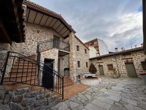 a stone building with a staircase and a patio at La Tahona Vieja in El Barraco