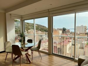 a living room with a table and chairs and windows at Apartamento moderno centro Aguilas 150m playa in Águilas +10 photos