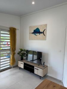 una sala de estar con una pintura de pescado en la pared en Blue House Lodge, en Faaa