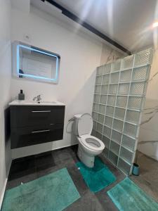 un baño con inodoro y lavabo en Blue House Lodge, en Faaa