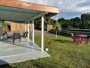 a pavilion with a table and chairs in a yard at Blue House Lodge in Faaa