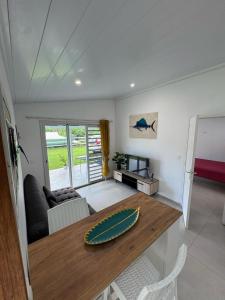 una sala de estar con una mesa y un sofá en Blue House Lodge, en Faaa 2 fotos más