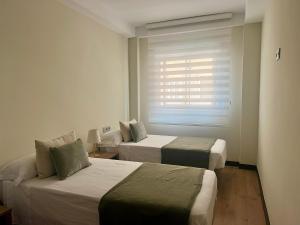 zwei Betten in einem Hotelzimmer mit Fenster in der Unterkunft Recién reformado! Oasis de lujo con vistas panoramicas in Águilas + 10 Fotos