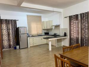 a kitchen with a refrigerator and a table in it at Maison de Pagoda in Port Louis