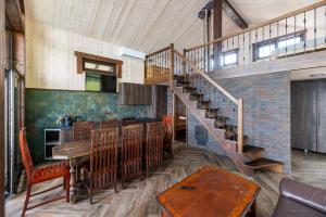 a living room with a staircase and a table and a dining room at Galuonu vilos Ezero in Inturkė +12 photos