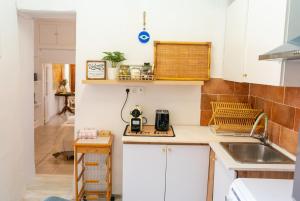 a small kitchen with white cabinets and a sink at Chrysa s house in Hydra