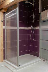 a shower with purple tiled walls in a bathroom at Suite La Mansion Casa Rural in La Toba