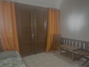 una camera da letto con una porta, un tavolo e una sedia di Appartement Vanille 2 a Sainte-Anne Altre 4 foto