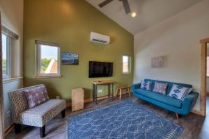 a living room with a blue couch and a tv at Stylish Casita Moab 2 - In Town, Outdoor Sauna in Moab