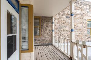 a wooden porch with a door and a stone wall at Stone Alley Condo condo in Telluride +9 photos