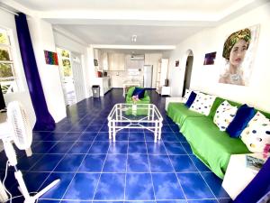 a living room with a green couch and a table at Le Maison Apartments-Gran Anse in Morne Rouge