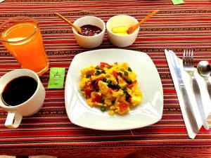 a table with a plate of food and a cup of coffee at Hospedaje K'uchuwasi in Ollantaytambo