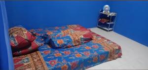 a bed in a room with a blue wall at Villa Daenk Bogor in Cinagara
