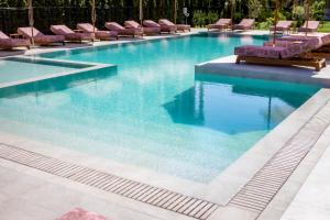 a swimming pool with chairs and blue water at J'ADORE Secret Garden A&K Deluxe Studio in Sunny Beach