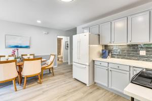 Newly Renovated Home in Oak Island! في أوك آيلاند: مطبخ وغرفة طعام مع طاولة وثلاجة