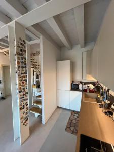 a room with a kitchen with a wall of wine racks at Le Vele Del Cigno in Peschiera del Garda