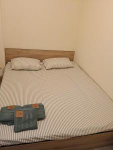 Una cama con dos almohadas y una manta encima. en Spital 1 cameră living, en Târgu Mureș