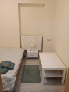 Un dormitorio pequeño con una cama y una mesa blanca. en Spital 1 cameră living, en Târgu Mureș