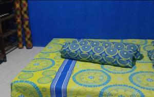 a bed with a yellow and blue blanket and pillows at Villa Daenk Bogor in Cinagara