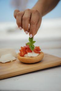 una persona che mette una foglia su un panino su un tagliere di Villa Castrignano a Monopoli