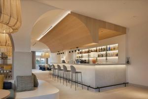 a kitchen with a bar with stools at Cala Ponte, a Tribute Portfolio Hotel in Polignano a Mare