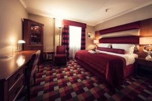 Postel nebo postele na pokoji v ubytování Carlton George Hotel