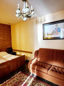 a bedroom with a couch and a bed and a chandelier at Sagamo in Sagamo