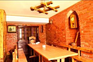 a room with a brick wall and a wooden table at Sagamo in Sagamo