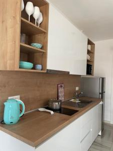 ネア・ペラモスにあるOpenSea2のキッチン(白いキャビネット、カウンターの青いマグカップ付)