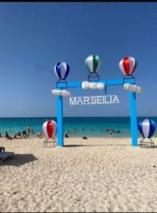 a sign on a beach with people in the water at العالمين in El Alamein