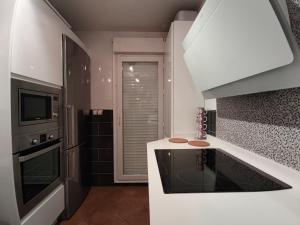 eine weiße Küche mit Spüle und Mikrowelle in der Unterkunft Chalet 3 hab vista rio Guadiana in Ayamonte + 15 Fotos