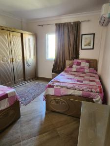 a bedroom with a large bed and a window at العالمين in El Alamein