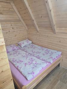 1 cama en una habitación de madera en una cabaña en A frame Ivona, en Bastasi