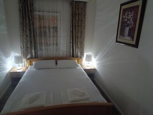 a bedroom with a bed with two lamps on both sides at Apartman Dali in Blagaj