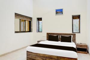 潘奇加尼Hotel O Ambassador Hotel Panchgani的一间卧室设有一张大床,部分设有窗户。