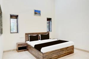 潘奇加尼Hotel O Ambassador Hotel Panchgani的房间里有一张大床的卧室