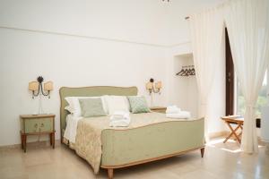una camera da letto bianca con un letto e una finestra di Villa Castrignano a Monopoli