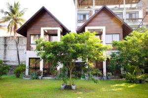 a house with a tree in front of it at Woodgrove Cabanas in Negombo