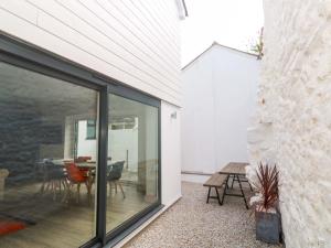een glazen uitbreiding van een huis met een tafel en stoelen bij 21 Alverton Street in Penzance