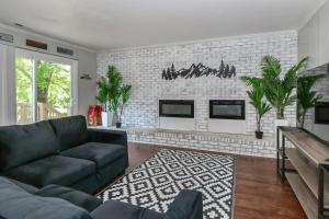 un salon avec un canapé et un mur de briques dans l'établissement The Gilead Cottage Near Lake Tillery & Uwharrie, à Mount Gilead
