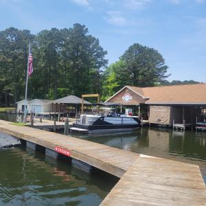 un bateau amarré à un quai à côté d'un bâtiment dans l'établissement The Gilead Cottage Near Lake Tillery & Uwharrie, à Mount Gilead